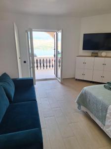 a living room with a couch and a bed and a television at Sun Anna Apartments in Pag