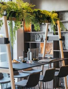 a dining room with a table and chairs and plants at Kyriad Chateauroux Nord - Aéroport in Déols