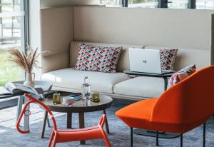 a living room with a couch and a table with a laptop at Kyriad Chateauroux Nord - Aéroport in Déols +42 photos