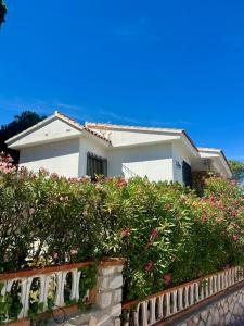 ein weißes Haus mit Blumen vor einem Zaun in der Unterkunft Bungalow Peñiscola REF 030 in Peñíscola