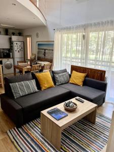 a living room with a black couch and a table at Caparica Golf & Beach Accomodation in Almada