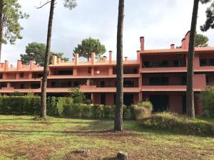 a large pink building with trees in front of it at Caparica Golf & Beach Accomodation in Almada