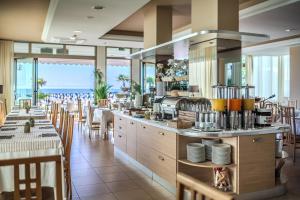 a restaurant with a bar with tables and chairs at Hotel Orizzonte in Lido di Jesolo