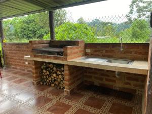 a outdoor kitchen with a grill and a sink at Palmerai BUCAY in Cumanda