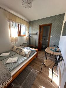 ein kleines Schlafzimmer mit einem Bett und einem Tisch in der Unterkunft Pokoje Gościnne Bartuś in Czarna Góra