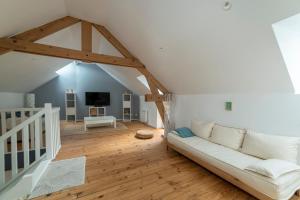 a living room with a white couch in the attic at Suisse Normande Refuge - Maison à la campagne 6p in Amayé-sur-Orne