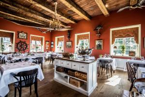 a dining room with tables and chairs and red walls at Dyvig Badehotel in Nordborg