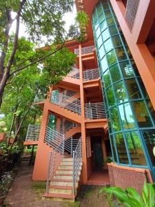 an orange building with stairs and a glass window at Krishna Beach Resort in Kannur