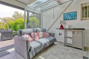 バツ・シュル・メールにあるMaison Batz-sur-mer piscineのソファと窓のあるリビングルーム