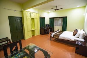 a bedroom with a bed and a table in a room at Krishna Beach Resort in Kannur