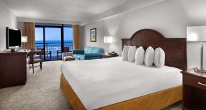 a hotel room with a large bed and a desk at Best Western Ocean Sands Beach Resort in Myrtle Beach +31 photos