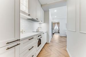 a white kitchen with white cabinets and a sink at Endla Residence in Tallinn +12 photos
