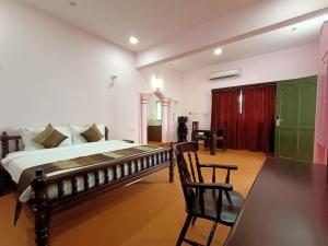a bedroom with a bed and a table and chairs at Krishna Beach Resort in Kannur