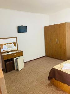 a room with two beds and a tv on a wall at Casa Andu in 2 Mai