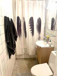 a bathroom with a toilet and a shower curtain with feathers at Two-room apartment in Stor København in Tåstrup