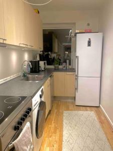 a kitchen with a white refrigerator and a sink at Two-room apartment in Stor København in Tåstrup
