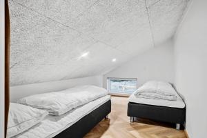 two beds in a room with a white ceiling at Exclusive Pool And Activity House For 30 People -1002 in Ringkøbing +28 photos