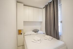 a small white bedroom with a bed with two towels at Villa Lucija in Milna +96 photos
