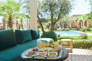 a tray of food on a table in front of a pool at Villa du Cedre in Marrakesh