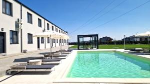 a pool with chairs and umbrellas next to a building at X rent apartment in Prim Decembrie