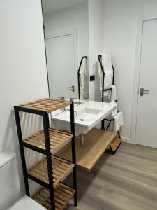 een badkamer met een wastafel en een grote spiegel bij Apartamentos Turísticos Vidal Costa in Foz +11 foto's