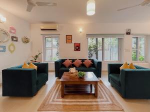 uma sala de estar com dois sofás e uma mesa de centro em Rainforest Enclave, Arpora - 10 mins to Baga beach em Arpora