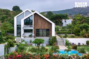 ナーシクにあるStayVista at The Rainfield Villa with Gazebo & Lawnのプール付きの家
