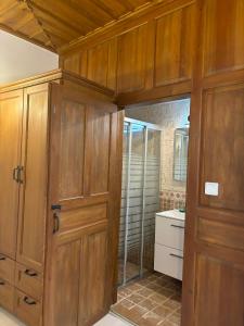 a large bathroom with wooden cabinets and a shower at Taşdelen Hotel in Alaçatı