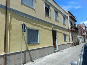 a yellow building with a parking meter on a street at Simbilis B&B Holiday Experience Mimose in Quartu SantʼElena +9 photos