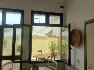 a dining room with a table and a window at Simbilis B&B Holiday Experience Mimose in Quartu SantʼElena
