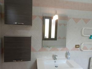 a bathroom with a sink and a mirror at Simbilis B&B Holiday Experience Mimose in Quartu SantʼElena