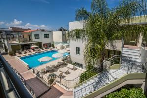an apartment with a pool and a palm tree at Athina Beach Hotel in Kato Daratso