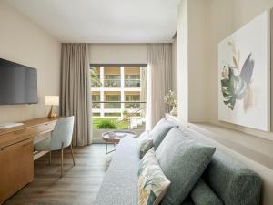 ein Wohnzimmer mit Sofa, Schreibtisch und Fernseher in der Unterkunft MarBella, Mar-Bella Collection in Agios Ioannis Peristerion