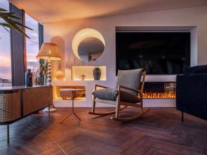 a living room with a chair and a fireplace at Doubletree By Hilton Nice Centre Iconic in Nice