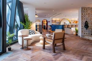 a lobby with white furniture and large windows at Doubletree By Hilton Nice Centre Iconic in Nice