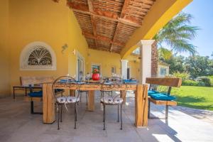 ein Esszimmer im Freien mit einem Holztisch und Stühlen in der Unterkunft Villa D'Amour - Golfe de St Tropez in Préconil