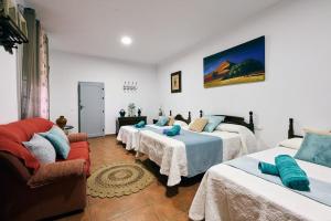 Habitación con 4 camas y sofá en Casa Peñacerrada, en Ronda