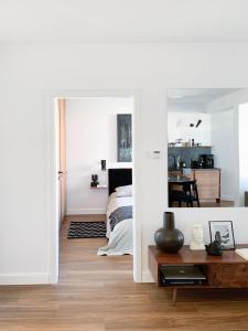 une chambre avec un lit et une pièce avec un miroir dans l'établissement Designer Wohnung nur 450 m vom Strand entfernt!, à Darłowo