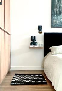 une chambre avec un lit et un tapis noir et blanc dans l'établissement Designer Wohnung nur 450 m vom Strand entfernt!, à Darłowo