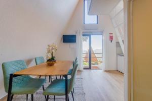 una sala da pranzo con tavolo in legno e sedie blu di Cabana Sobreiro a Castelo de Paiva