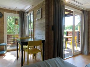 a room with a table and chairs and a bedroom at Guldborg Camping & Cottages - Superior in Guldborg +4 photos