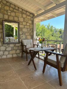 a patio with a table and chairs and a mirror at Taşdelen Hotel in Alaçatı