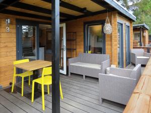 a wooden deck with a wooden table and chairs at Guldborg Camping & Cottages - Superior in Guldborg
