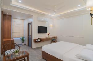 a hotel room with a bed and a tv at Hotel Ganga Maiya in Lucknow