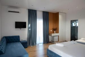 a hotel room with two beds and a couch at Summer Point Hotel in Ksamil