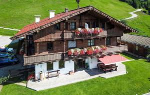 a large wooden house with flowers on the balcony at Apartment Blick Hohen Salve in Hopfgarten im Brixental +9 photos