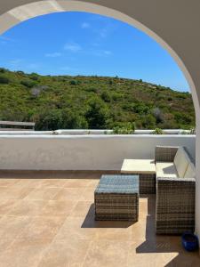 a patio with a table and wicker chairs on a roof at Appartement familial avec balcon et piscine in Martil