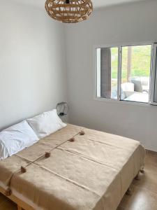 a bed in a room with a large window at Appartement familial avec balcon et piscine in Martil