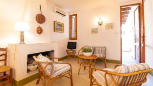 a living room with a fireplace and chairs at Villa Brezza di Mare-Geremeas Country Club in Maracalagonis