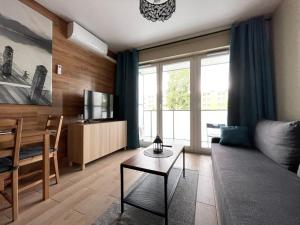 una sala de estar con un sofá y una mesa en Superior Baltea 2 rooms, 1 bedroom, Beach 800m, Air Condition! Terrace, en Gdansk